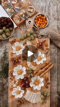 a wooden cutting board topped with fruits and vegetables next to other foods on top of a table