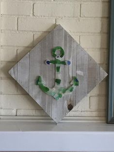 a wooden sign with an anchor painted on it