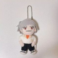 a keychain with an anime character hanging from it's side on a white wall