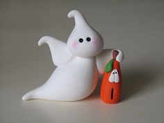 a white ghost figurine next to a carrot