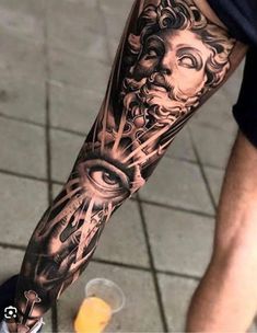 a man's arm with an all seeing eye tattoo on the left side of his leg