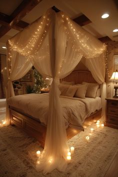 a canopy bed with candles on the floor and lights hanging from it's sides