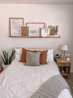 a bed with white comforter and pillows on top of it next to two wooden nightstands