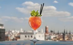 a drink on top of a roof with a view of the city