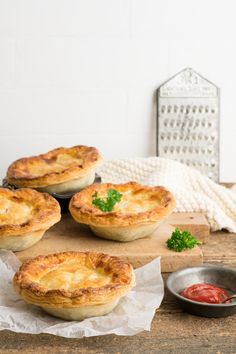 four pies sitting on top of a wooden cutting board