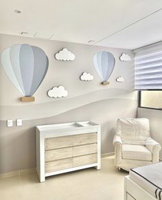 a baby's room with hot air balloons on the wall