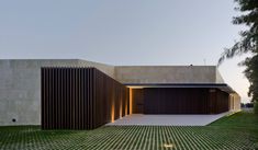 the house is made out of concrete and has large windows