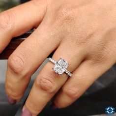 a woman's hand with a diamond ring on her finger and an engagement band