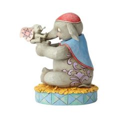 an elephant figurine holding a small bird