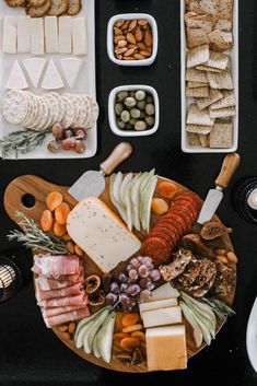 an assortment of cheeses, meats and crackers on a platter