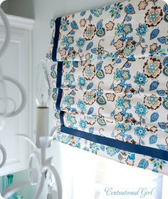 a window valance with blue and brown flowers on it, hanging from the ceiling