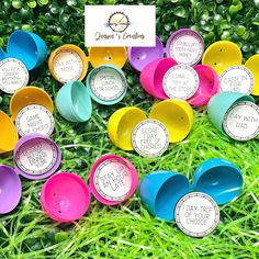 some colorful cups are sitting in the grass with labels on them that say happy birthday