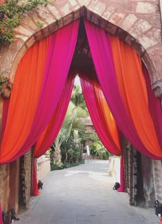 an archway with red and orange drapes on it