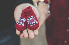 two people holding hands with red mittens on them