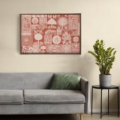 a grey couch sitting next to a plant in a living room