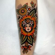 a woman's face is surrounded by flowers and leaves on this leg tattoo design