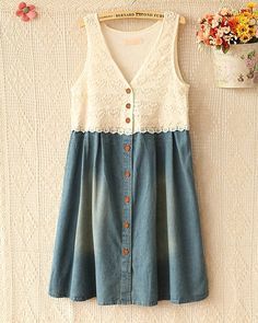 a white and blue dress hanging on a wall next to a potted plant with flowers