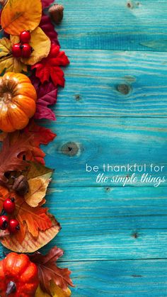 a blue wooden background with autumn leaves and berries on the bottom right corner is a quote that says, be grateful for all the simple things in life