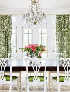 a dining room table with chairs and a chandelier hanging from it's ceiling