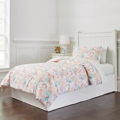 a white bed with a pink and blue comforter