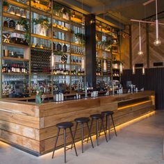 a bar with stools and shelves filled with bottles