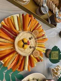 a table topped with lots of different types of food next to crackers and plates