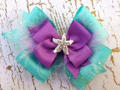 a purple and blue hair bow with a starfish on it