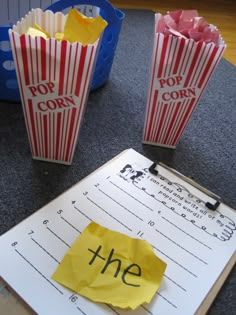 two popcorn bags with the word the on them are next to a piece of paper