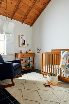 a baby's room with a crib, rocking chair and rug on the floor