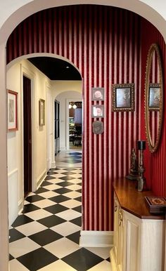 the hallway is decorated with red and white striped wallpaper, black and white checkered floor