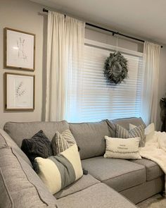 a living room filled with furniture and a wreath on the window sill above it