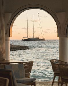 a boat sailing in the ocean through an archway