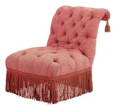 a pink chair with tassels on it