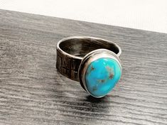 "Made by hand, using 925 Sterling silver and beautiful blue Turquoise, I believe to be Kingsman Turquoise. The textured band is slightly over 1/4\" wide with hammered texture. Bezel set stone in a simple, classic setting. The stone is about 1/2\" by 3/8\". Oxidized patina and tumbled to a satin finish. Size 9, but since the band is on a wide size, Size 8.75 would be a better fit. Ready to ship in a gift box. I do have few more beautiful stones like this one, so if a different size is required, I Rustic Sterling Silver Turquoise Ring Gift, Rustic Silver Turquoise Ring For Gift, Rustic Silver Turquoise Ring Gift, Silver Turquoise Ring With Oxidized Finish As A Gift, Rustic Silver Rings With Patina, Handmade Rustic Silver Turquoise Ring, Beautiful Stones, Modern Ring, Blue Turquoise