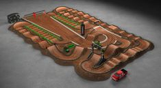 a dirt track with cars and trucks driving around it in the middle of an open area