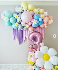 balloons and streamers are arranged in the shape of numbers for a balloon wall decoration