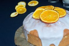 an orange bundt cake with icing and sliced oranges