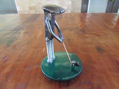 a metal figurine is standing on a green plate