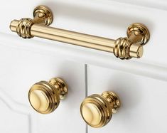 the handles and knobs on this white cabinet are brass - plated, but it's not too hard to tell