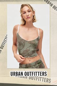 Out From Under tank top & micro short set in a camo-print pointelle knit. Features a slim & cropped fit tank and elastic waist, relaxed micro shorts. All trimmed in lace, bows and ruffle lettuce-edge trim for femme flair. Exclusively at Urban Outfitters. Features Out From Under Angie pointelle cami Pointelle knit pj set Soft & stretchy camo print pointelle knit Scoop neckline tank with spaghetti straps with bow details Elastic waist micro shorts with lettuce-edge trim Slim stretch fit Cropped length Easy pull-on style UO exclusive Content + Care Includes top and shorts 100% Cotton Machine wash Imported Size + Fit Model in Tan is 5’9" and wearing size Small Measurements taken from size Small Chest: 24" Length: 17" Waist: 26" Inseam: 2" | Out From Under Camo Printed Pointelle Cami & Micro Sh Summer Cropped Tank Top For Loungewear, Cropped Tank Top For Summer Loungewear, Summer Tank Crop Top For Loungewear, Trendy Summer Camouflage Top, Trendy Camouflage Summer Top, Trendy Camouflage Tops For Summer, Summer Stretch Camouflage Tops, Casual Loungewear Crop Top Camisole, Spring Loungewear Crop Top Camisole