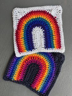 two crocheted potholders with a rainbow design on the top and bottom one is white