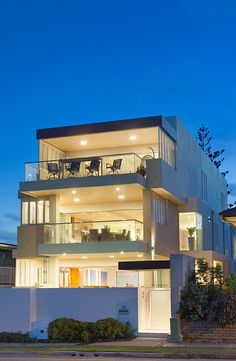 a large white building with balconies and lights on it's sides at night