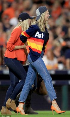 two women are walking on the field together