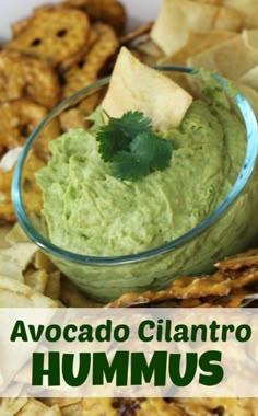 a bowl filled with guacamole surrounded by chips and tortilla chips