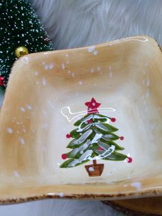 a wooden bowl with a christmas tree painted on it