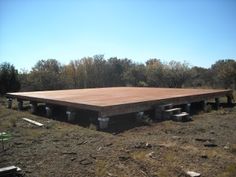 a large wooden structure sitting in the middle of a field