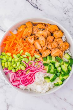 a bowl filled with rice, carrots, cucumbers and shrimp