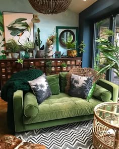 a living room filled with green furniture and lots of plants on top of the couch