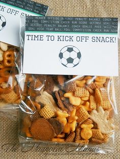 two bags filled with snacks sitting on top of a table next to a sign that says time to kick off snack