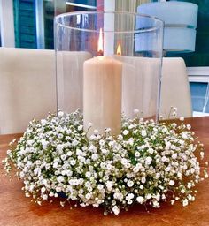 a candle is lit on a table with flowers